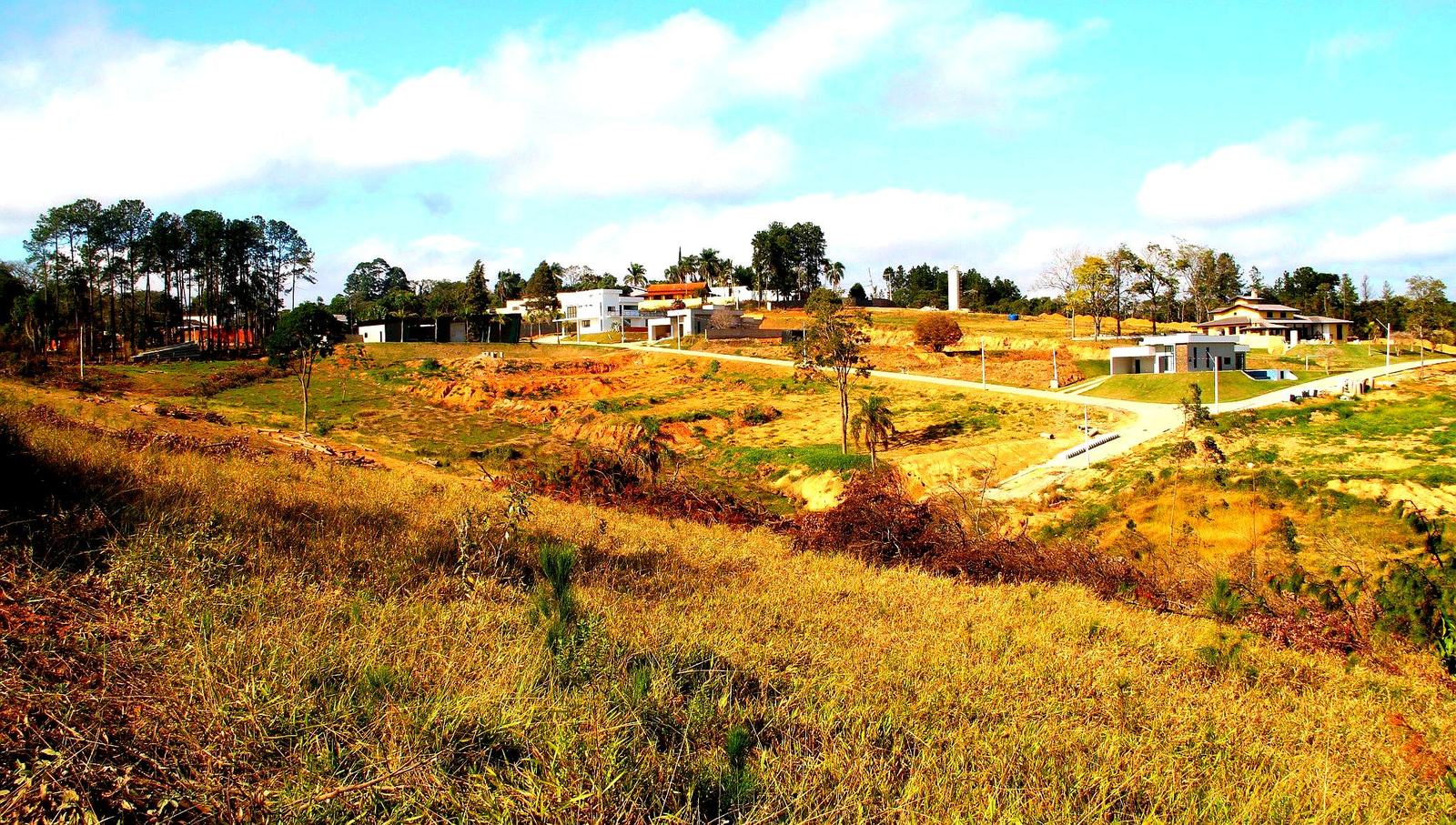 Vista geral do loteamento em Dona Catarina, com ruas, casas prontas e lotes vazios